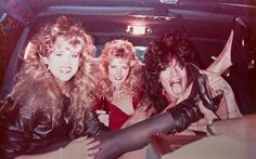 three women sitting in the back of a car with their hands on their hipss