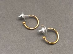 Gold plated Mini Creole Earrings. The hoop is 1cm diameter. The earrings are made from brass, and the posts are sterling silver. ------------------------------------------ You may also be interested in -  Our Recycled Glass and Gold Circle Earrings:  https://www.etsy.com/uk/listing/524538124/green-recycled-glass-gold-hoop-drop?ref=shop_home_active_4 Our Malachite and Gold Circle Earrings:  Our Recycled Glass Ball Pendant:  https://www.etsy.com/uk/listing/523202258/recycled-glass-ball-pendant-nec Gold Hoop Plug Earrings As Gift, Gold Hypoallergenic Hoop Plug Earrings, Hypoallergenic Small Hoop Gold Plug Earrings, Adjustable Gold Wrap Single Earring, Adjustable Single Gold Wrap Earring, Gold Hoop Plug Earrings, Gold Small Hoop Plug Earrings For Everyday, Small Hoop Gold Plug Earrings, Gold Round Wrap Earrings