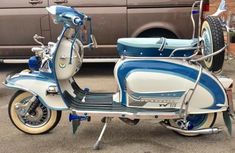 a blue and white scooter parked next to a van