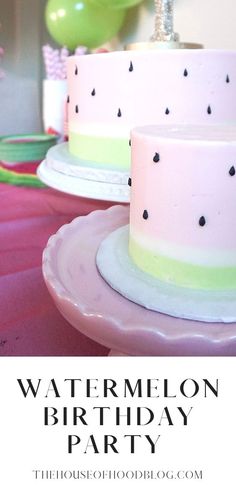 there is a pink and green birthday cake on the table with balloons in the background