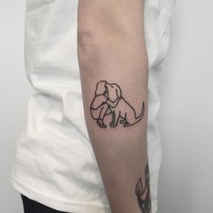 a woman's arm with a small tattoo of a dog sitting on top of it