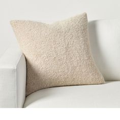 a white couch with a beige pillow on it