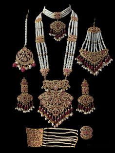 Ready to ship bridal set includes choker , earrings , jhoomar , tika , ring , bracelet and Rani haar made using cz stones , shell pearls , beads and gold plating Ceremonial Kundan Jewelry With Pearl Drop, Hand Set Ruby Bridal Sets For Wedding, Ruby Chandbali Jewelry Set With Stonework, Ruby Chandbali Jewelry Sets With Stone Work, Chandbali Ruby Jewelry Sets With Stone Work, Kundan Bridal Accessories With Tilla For Marriage, Bollywood Ruby Jewelry Sets With Stone Work, Ceremonial Temple Jewelry Bridal Sets Hand Set, Festive Hand Set Pearl Jewelry