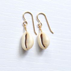 Simple & cute describe these whole cowrie shell earrings! They're the perfect accessory to wear with your favorite casual outfit when you're out & about. Please allow for variations in size and shape of shells as each is unique. Trendy Shell-shaped Jewelry Gift, Casual Shell Jewelry Gift, Cowrie Shell Dangle Earrings As Gift, Handmade Cowrie Shell Earrings For Gift, Handmade Cowrie Shell Earrings As Gift, Handmade Shell Earrings For Summer, Cowrie Shell Dangle Jewelry For Gifts, Cowrie Shell Dangle Jewelry Gift, Shell Earrings With Ear Wire For Vacation