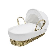 a wicker bassinet with white fabric and gold handles