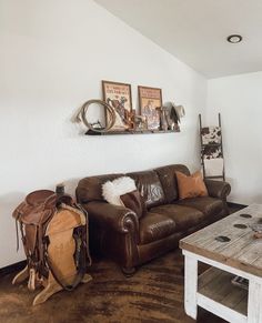 a living room filled with furniture and a wooden table in front of a white wall