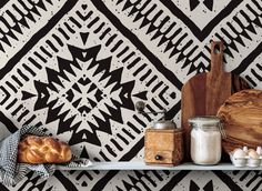 some food is sitting on a shelf in front of a black and white wallpaper