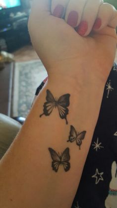 a woman's wrist tattoo with three butterflies on the left side of her arm