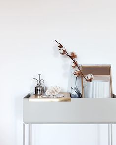 a white table topped with two mirrors and a vase filled with flowers on top of it