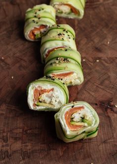 cucumber rolls are arranged on a wooden table