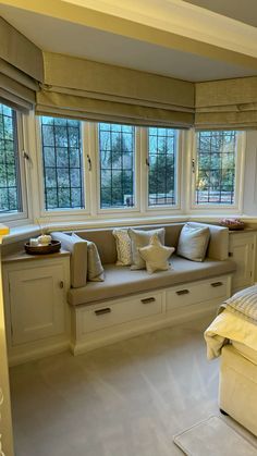 a bedroom with white furniture and large windows