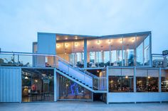 a building with stairs leading up to it and people sitting at tables in the background