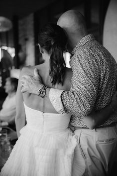 a man and woman embracing each other in black and white