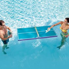 two people are playing ping pong in the pool