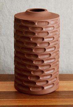 a brown vase sitting on top of a wooden table