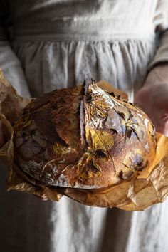 a person holding a loaf of bread in their hands