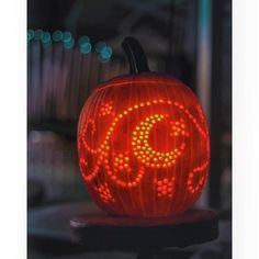 an illuminated pumpkin with the letter c on it's face and letters painted on its side