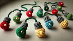 small crocheted christmas lights are arranged on a white surface with green, red and yellow lights