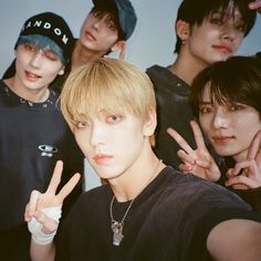 group of young men posing for the camera with their fingers in the shape of two peace signs