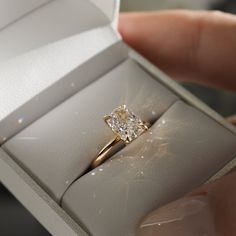 a person is holding a ring in a box