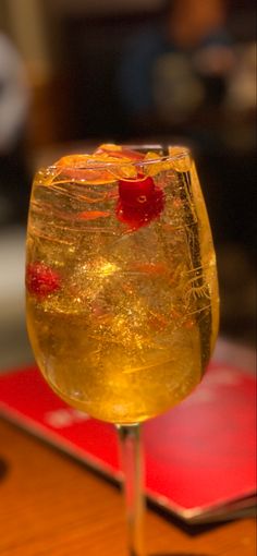 a glass filled with liquid sitting on top of a wooden table