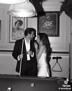 a man and woman standing in front of a pool table