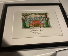 the framed artwork depicts a house and trees