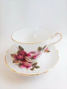 a cup and saucer with pink flowers on it