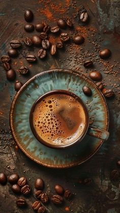 a cup of coffee sitting on top of a saucer next to some coffee beans