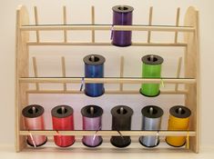 several spools of thread are hanging on a rack