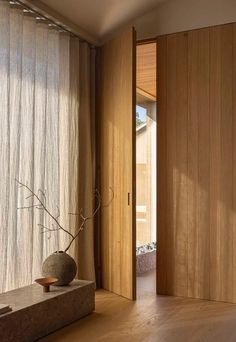 a vase sitting on top of a table next to a window