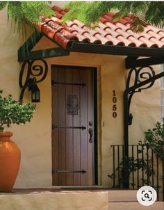 the front door of a house with potted plants