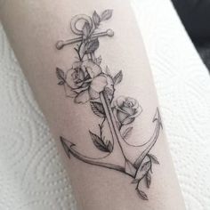 an anchor with roses on the side of its arm is shown in black and white