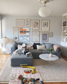 a living room filled with furniture and pictures on the wall