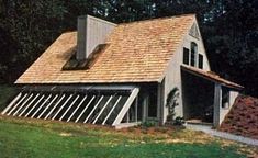 a small house with a roof made out of wood and shingles on the side