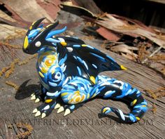 a blue and yellow dragon figurine sitting on top of a wooden table