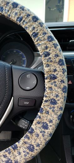 the steering wheel cover is covered with blue flowers and has a floral pattern on it