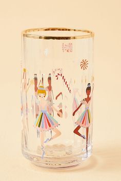 a shot glass with two dancers painted on the side and candy canes in the background