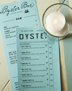 the menu for oyster bar is next to a lit candle