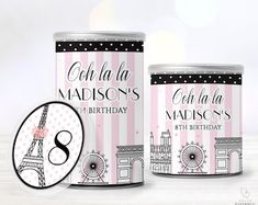 two pink tins with the number eight on them and an eiffel tower in the background