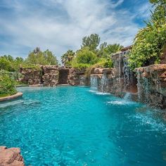 an outdoor pool with waterfall and blue water