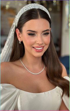 a woman wearing a tiara and smiling at the camera with her hair in a half up style