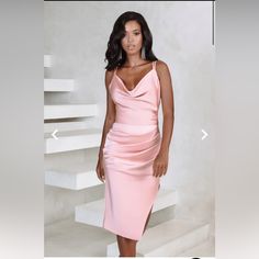 a woman in a pink dress posing for a photo with stairs behind her and the caption's below it