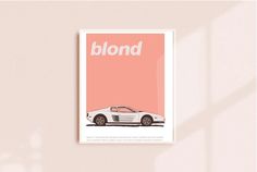 a white sports car sitting on top of a wall next to a pink poster that says blond