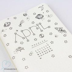 an open notebook with space themed writing on it