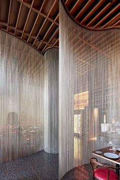 the interior of a restaurant with sheer curtains on the walls and tables in the middle