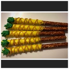 four corn on the cob sticks with green leaves and yellow glaze, ready to be eaten