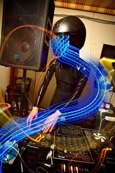 a dj mixing in front of a sound board with blue light streaks coming out of it