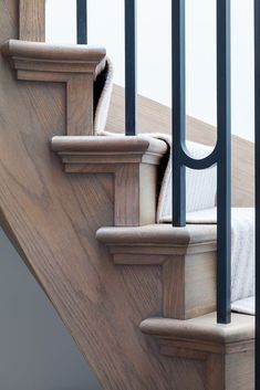 a wooden stair case with metal handrails