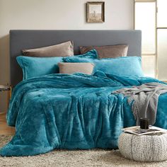 a bed with blue comforters and pillows in a bedroom